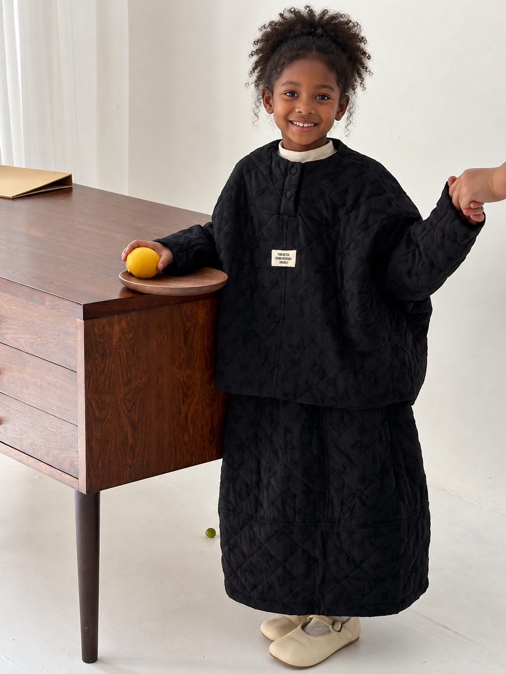Black quilted two-piece skirt set on Ethiopian child model